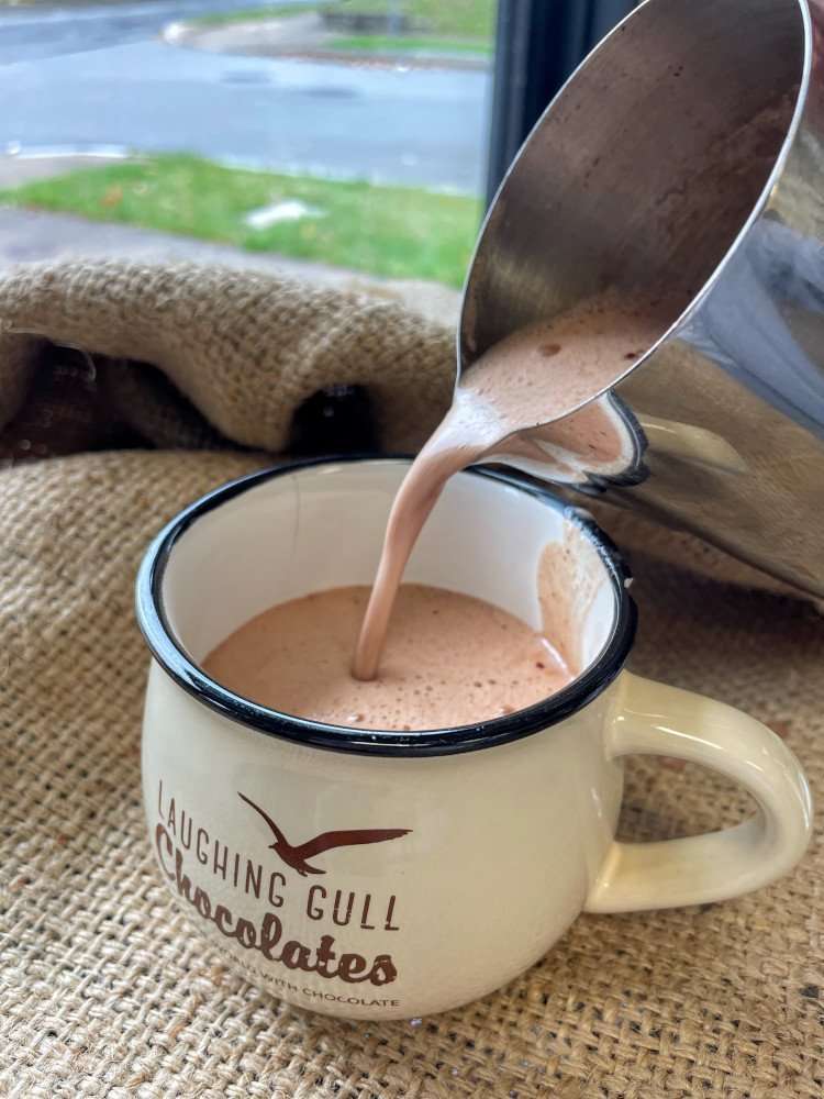 Pouring hot chocolate into Laughing Gull Chocolates mug