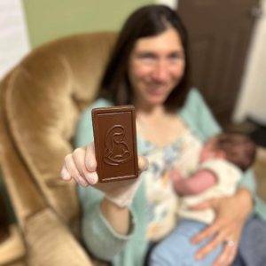 Woman holding baby and showing a breastfeeding chocolate mold