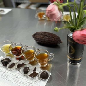 tea and chocolate flight pairing with a cacao pod and flowers in a can of beer